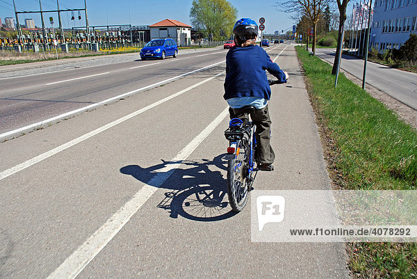 Siebenjähriger Junge mit seinem Fahrrad auf dem Radweg  Ulm  Baden-Württemberg  Deutschland  Europa