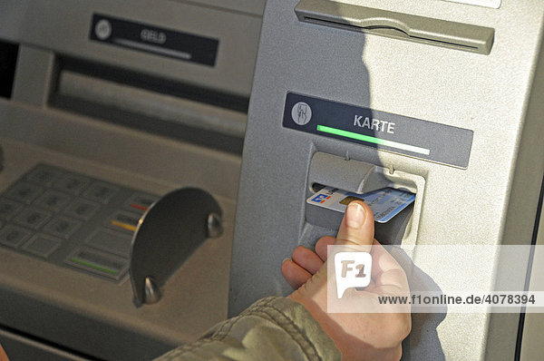 Hand eines achtjährigen Jungen mit eigener EC-Karte am Geldautomat  Deutschland  Europa