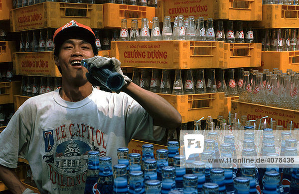 Soft drinks  young man wearing a Coca-Cola hat  pepsi and coke bottles in beverage crates of a Vietnamese brand  Vietnam  Asia