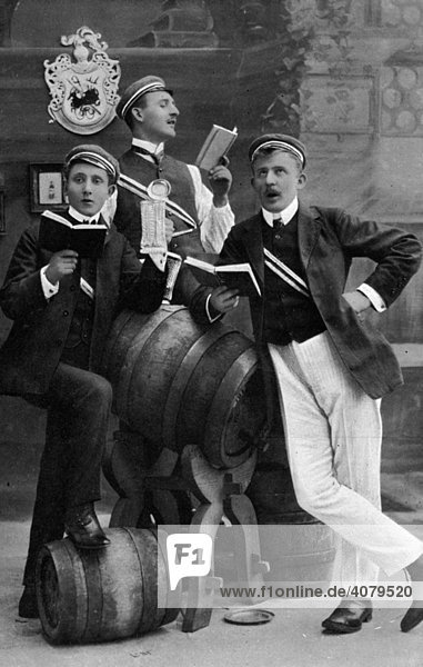 Studenten einer Studentenverbindung singen mit Gesangsbuch neben Bierfässern  historische Aufnahme  ca. 1910