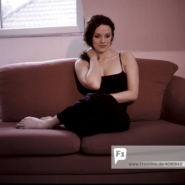 Brunette woman sitting on sofa
