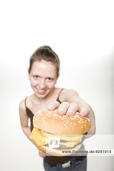 Frau hält einen Cheeseburger
