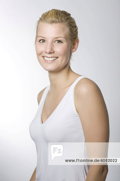 Portrait einer lachenden jungen Frau im weißen Shirt