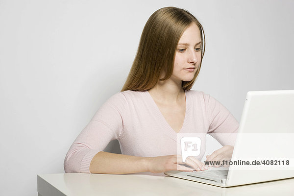 Junge Frau arbeitet an einem weißen Notebook