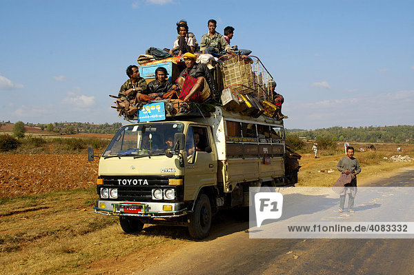 Viele Männer und Gepäck stapeln sich auf dem Dach eines Toyota Kleinlasters bei Pindaya Shan State Burma