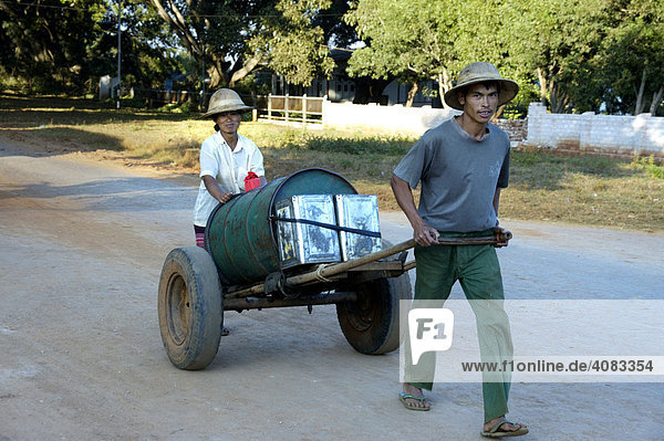 Mann und Frau holen Trinkwasser in einem Faß auf einer Karre Pindaya Shan State Burma