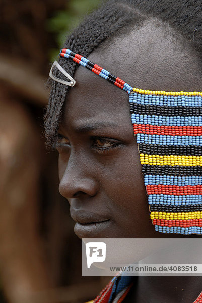 Portrait junges hübsches Mädchen mit buntem Kopfschmuck auf dem Markt von Keyafer Äthiopien