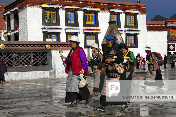 Tibetische Pilger mit Gebetsmühlen auf der Kora am Jokhang Tempel Lhasa Tibet China
