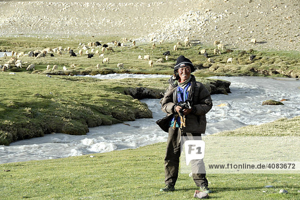 Hirte mit Lamm im Arm am Fluß bei Lungchang Tibet China