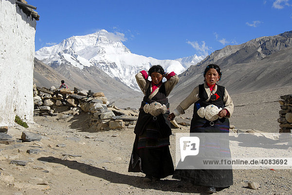 Two Tibetan pilgrims women in front of Mt. Everest Chomolungma Rongbuk Monastery Tibet China