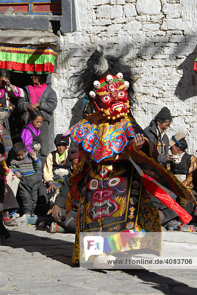 Monk wears fearful and red mask and dress of a demon at festival in colourful decorated Rongbuk Monastery Tibet China