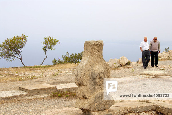 Two men at a carved rock at the archaeological site of Vouni North Cyprus