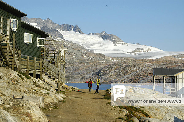 Two children in settlement at ice-capped mountain Tiniteqilaaq Eastgreenland