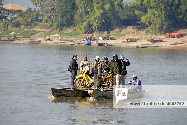 Adventurous ferry with people and a motobike across the Mekong River Champasak Laos