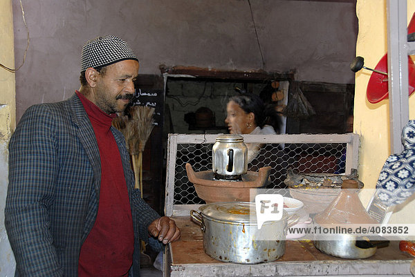 Koch und Verkäufer von Suppe und Tagine in seiner kleinen Küche Mellah Medina Marrakech Marokko