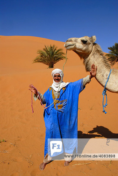 Tuareg trägt blaues Gewand mit weißem Turban in sand dunes Erg Chebbi Merzouga Marokko