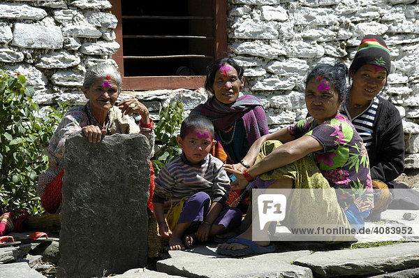Familie mit bunter Farbe auf der Sitrn zum Holi Fest Birethanti Annapurna Region Nepal