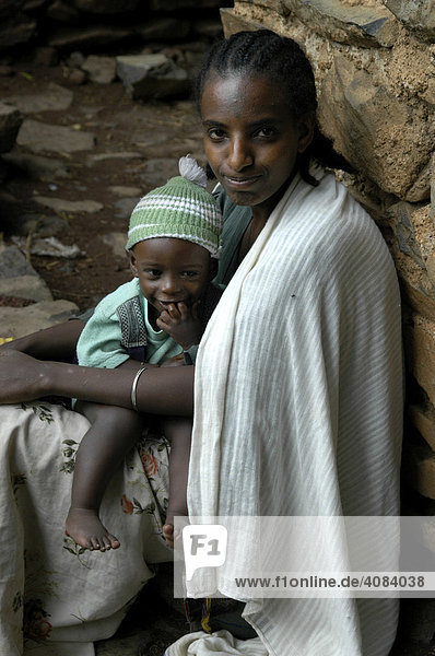 Junge Mutter mit Baby an einer Mauer der Dreieinigkeitskirche Debre Berhan Selassie Gondar Äthiopien