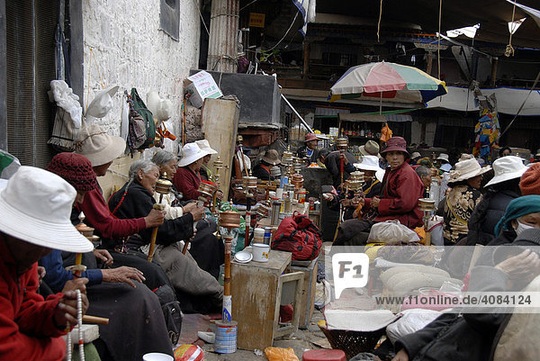 Versammelte buddhistische Pilger meditieren mit Gebetsmühlen Jokhang Lhasa Tibet China