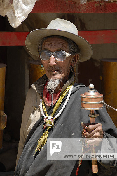 Tibetischer Buddhismus Pilger mit Bart dreht Gebetsmühle Shegar town Tibet China