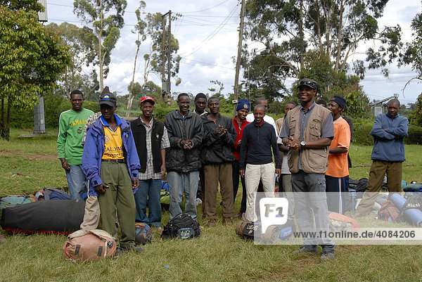 Einheimischer Bergführer mit versammelter Mannschaft an Trägern am Marangu Gate Kilimandscharo Tansania