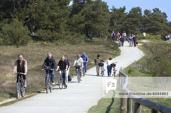 Hiddensee island Mecklenburg Vorpommern Germany path with biker and hiker to the lighthouse on the hill Schluckswiek