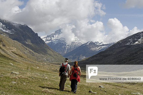 Gran Paradiso National Park between Piemonte Piedmont and Aosta valley Italy Garian Alps hikers at the old path to the Val Salvarenche at the high plateau Plan di Nivolet
