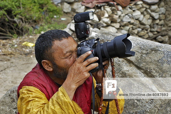 Monk with camera  Chim-puk Hermitage near Tsethang close to Lhasa  Tibet  Asia