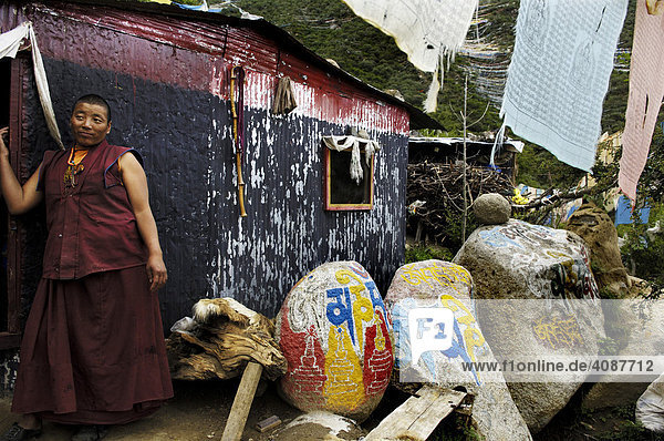 Nonne  Gebetsfahnen  Manisteine und Blechhütte  Chim-puk Hermitage bei Tsethang nahe Lhasa  Tibet  Asien