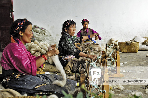 Tibetan women with a archaic spinning wheels  carpet manufacture  Shigatse  Tibet  Asia