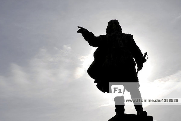 Silhouette of a statue in back light  hand pointing on one direction