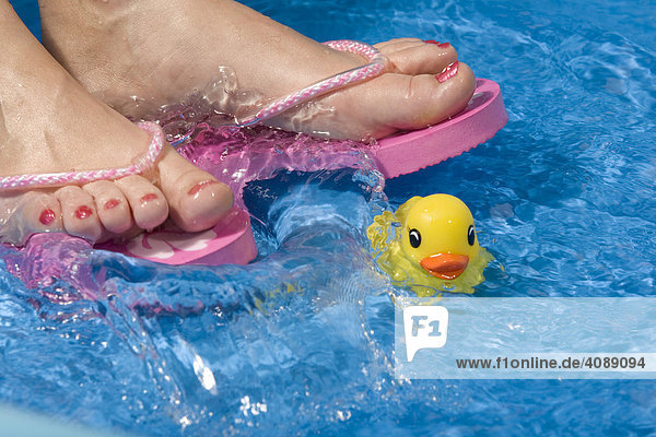 Füße mit Flip-Flops Plantschbecken Badeente