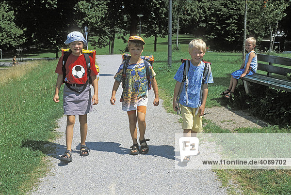 Drei Grundschulkinder auf dem Weg zur Schule