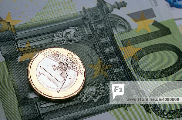 1-Euromünze liegt auf Euroscheinen