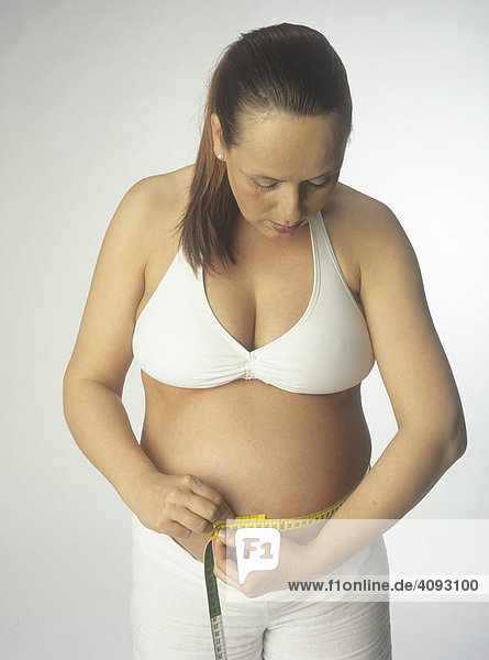 Frau  schwanger  misst Bauchumfang