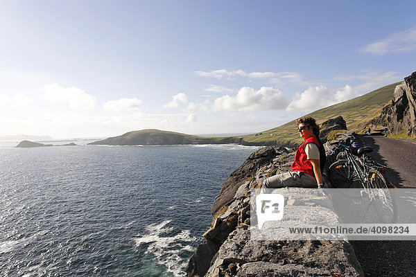 A female cyclist enjoys the sun  Slea Head  Dingle peninsula  Kerry  Ireland