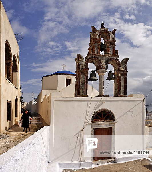 Alte Frau schwarz gekleidet und Kirche mit Glockenturm  Pyrgos  Santorin  Griechenland