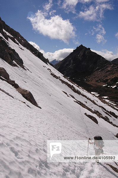 Wanderer erklimmt die verschneiten Abhänge oberhalb Refugio Frez  Bariloche  Patagonien  Argentinien