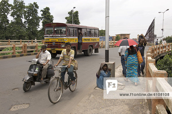 Straßenszene in Howrah die den Kontrast in der modernen indischen Gesellschaft veranschaulicht  verkrüppelter Bettler neben neuer Mittelschicht  Howrah  Hooghly  Westbengalen  Indien