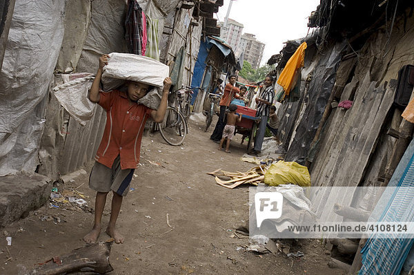 Ein kleiner Junge in den Slums von Topsia  dahinter kann man die vollklimatisierten  besseren Adressen Kolkatas sehen  Kolkata  Kalkutta  Westbengalen  Indien