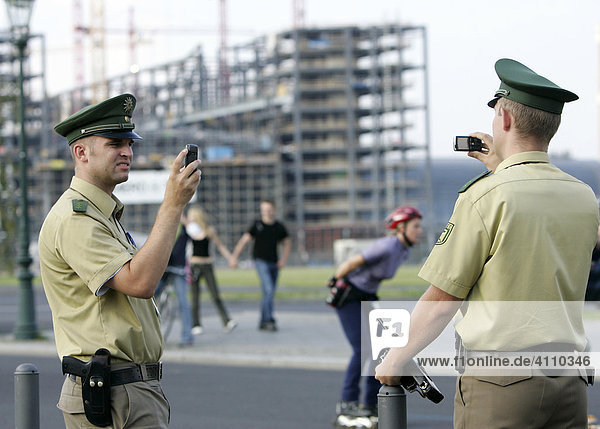 Policemen are taking pictures of each other via mobile phones