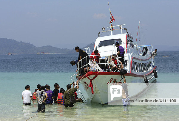 Asian tourists entering their boat for the next trip at the coast of the island Koh Kradan  Andaman Sea   Thailand  Asia