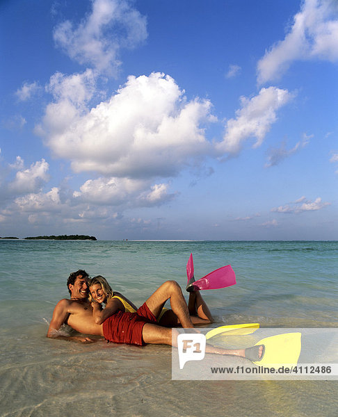 Junges Paar mit Schnorchelausrüstung im seichten Wasser  Strand  Malediven