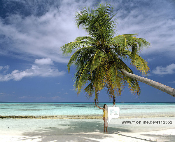 Junge Frau unter einer Palme  Erholung  Strand  Meer  Malediven
