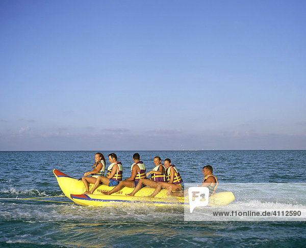 Young people on a banana boat  watersport and fun  Maldives  Indian Ocean