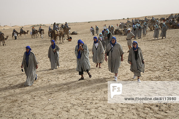 Touristen in arabischer Kleidung am Rande der Sahara in der Nähe von Douz  Tunesien