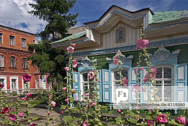 Sommerblumen vor schönen Fenstern mit Zierrahmen an alten Holzhäusern  Omsk an den Flüssen Irtisch und Omka  Omsk  Sibirien  Russland  GUS  Europa Holzhäuser