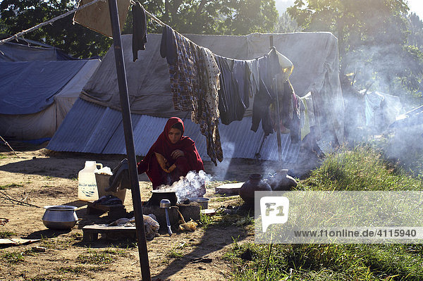 Frau an einer offenen Feuerstelle in Jabba  einem Camp für Erdbebenopfer  Balakot  NWFP  Pakistan
