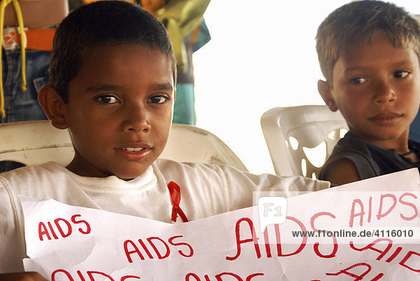 Brazilian boy on the World Aids Day (December 1st) with a banner an the Red Ribbon - symbol for solidarity with HIV-positive people  Fortaleza  Ceara  Brazil