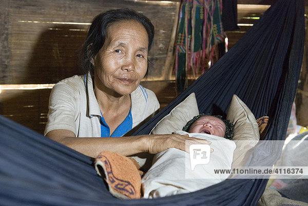 Hebamme wiegt Baby in der Hängematte  Flüchtlingslager Ei Tu Hta  Flüchtlingsgebiet an der Grenze zu Thailand nahe Mae Sariang  Burma